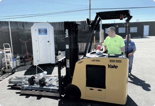A Fast Line Instructor giving an Onsite Stand up Forklift training course. Student on a Yale Narrow Aisle Reach Truck next to instructor on job site